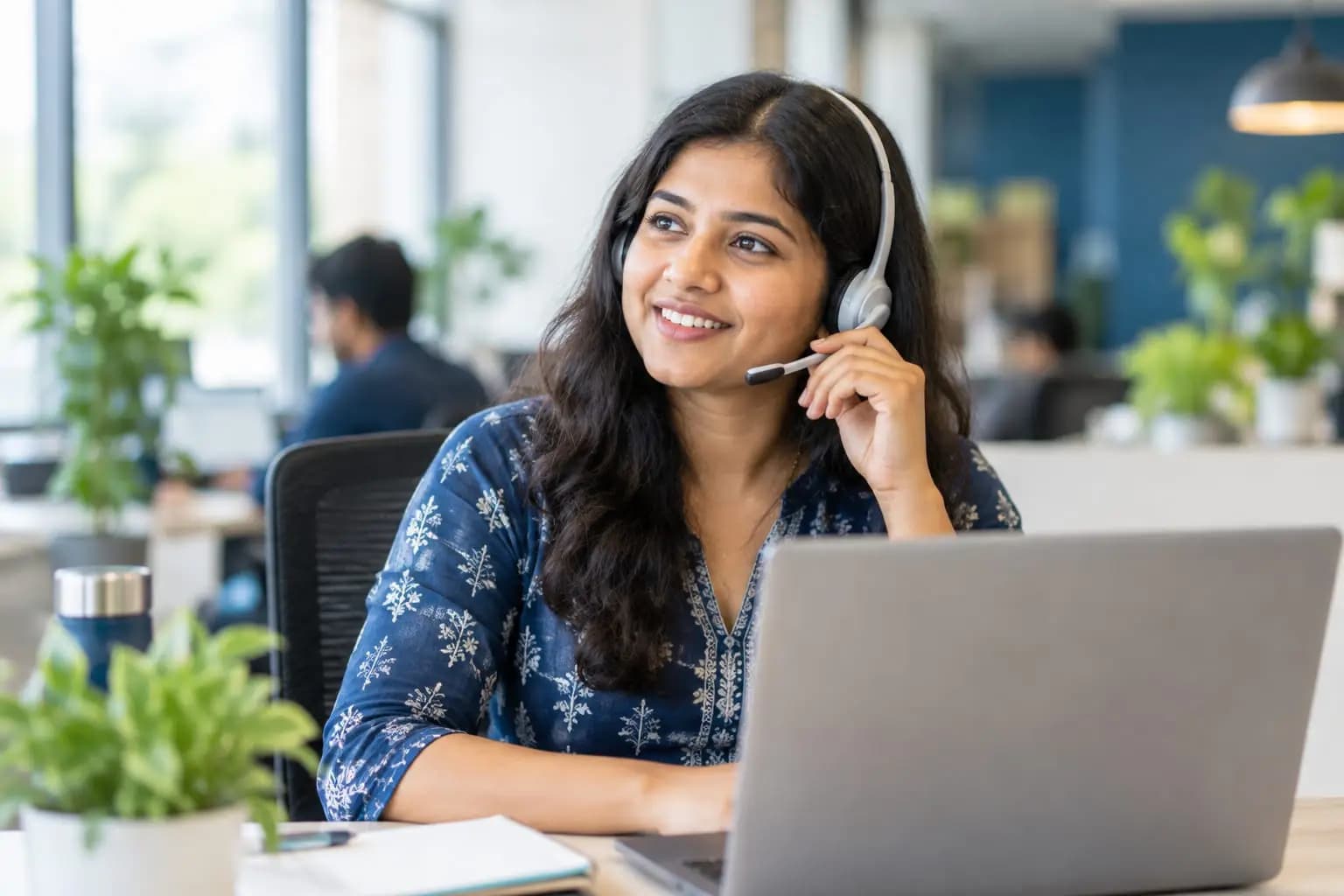 A support specialist wearing a headset, talking to a customer.